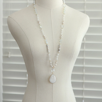 Long stone pendant necklace displayed on a mannequin