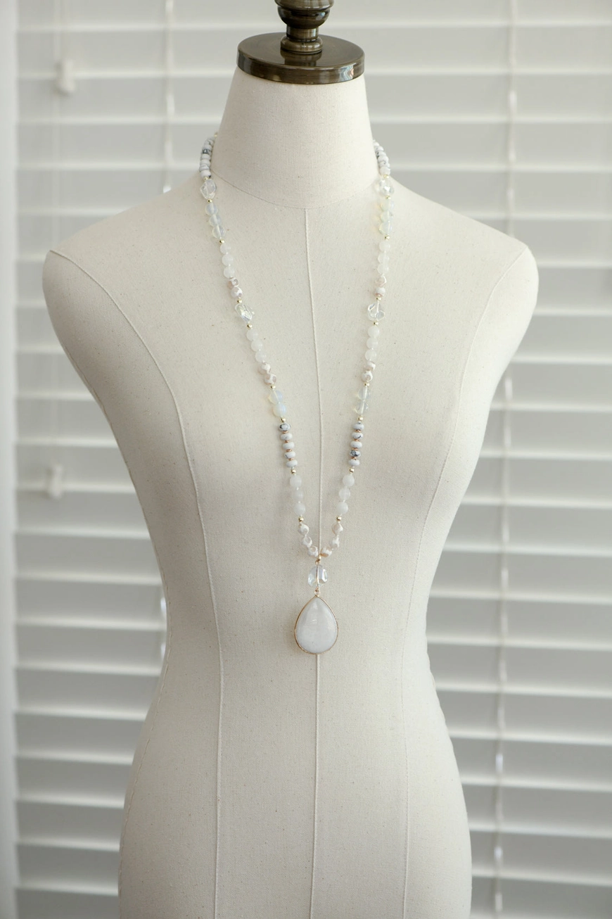 Long stone pendant necklace displayed on a mannequin