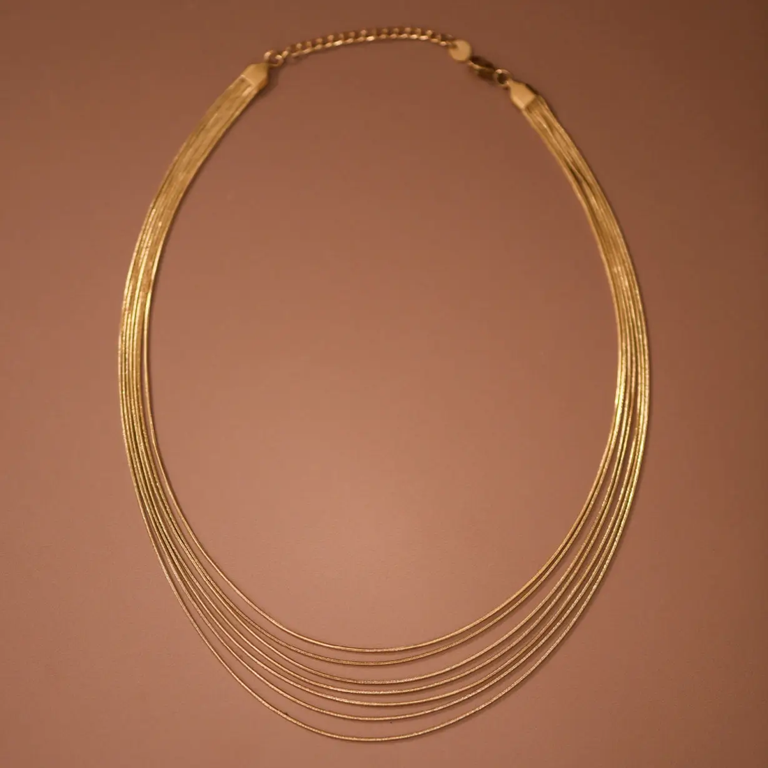 Layered gold necklace shown on model