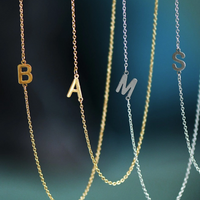 Gold and silver waterproof initial necklaces displayed together