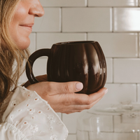Black 19 oz pumpkin mug held in a kitchen