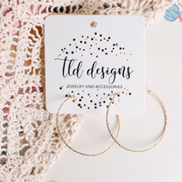Textured gold-plated hoop earrings on a TLD Designs card