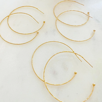 Three pairs of textured gold-plated hoops shown for styling; sold as one pair