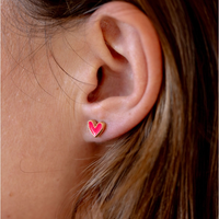 Hot pink enamel heart stud earring worn on an ear